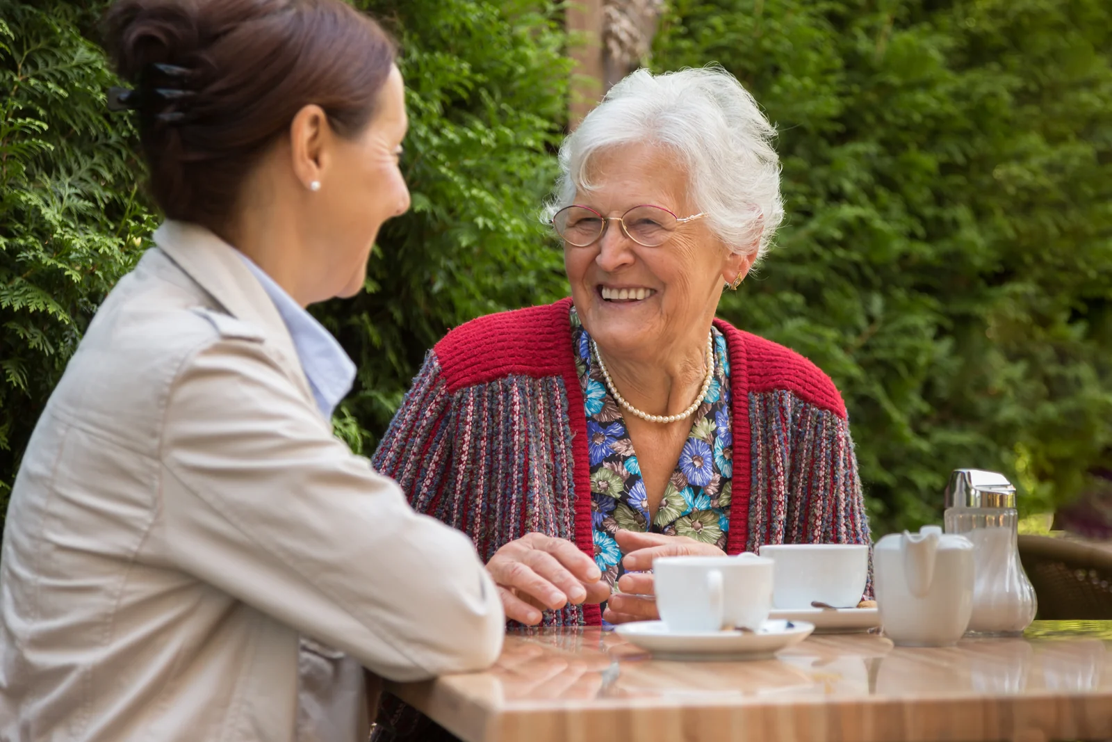 Eine ältere und eine jüngere Frau unterhalten sich bei einer Tasse Tee.